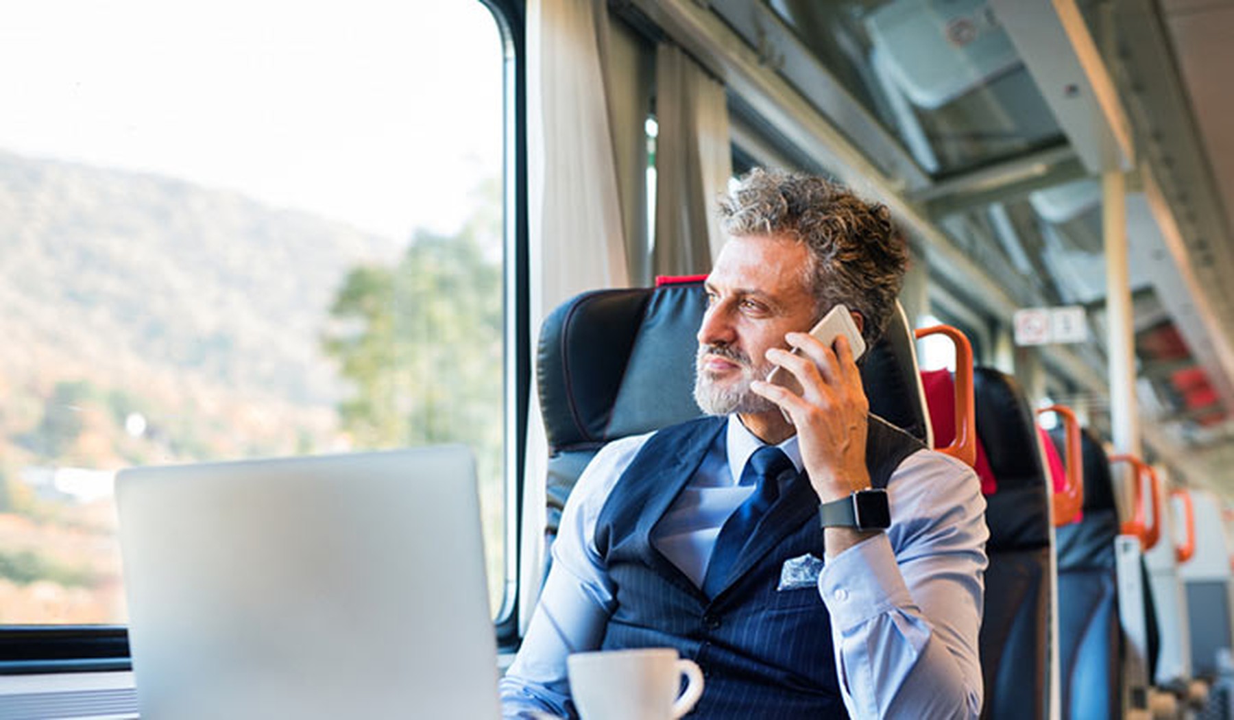 Hombre de mediana edad de negocios hablando por teléfono en el tren