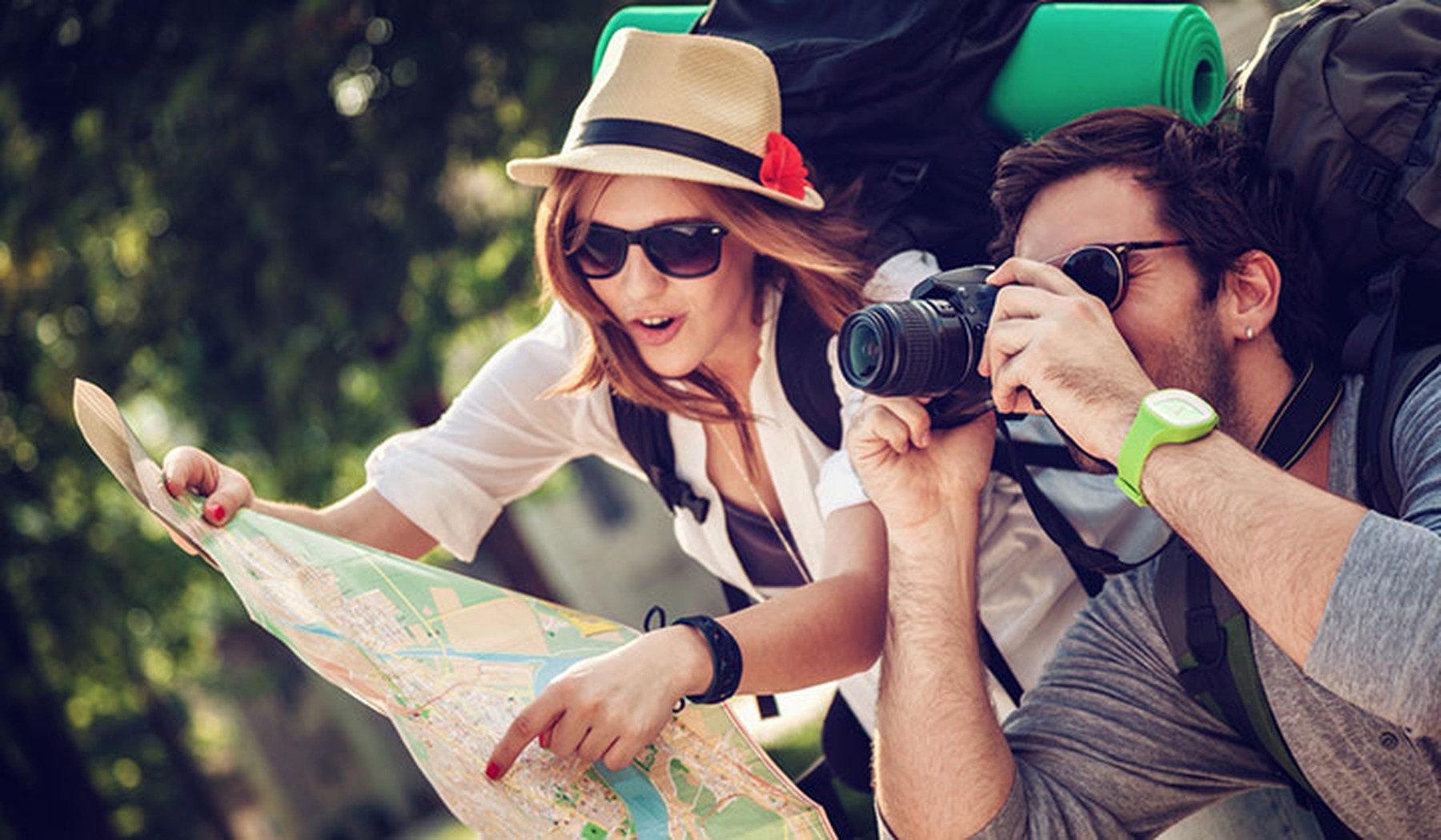 Mujer y hombre turistas con un mapa y una cámara de fotos