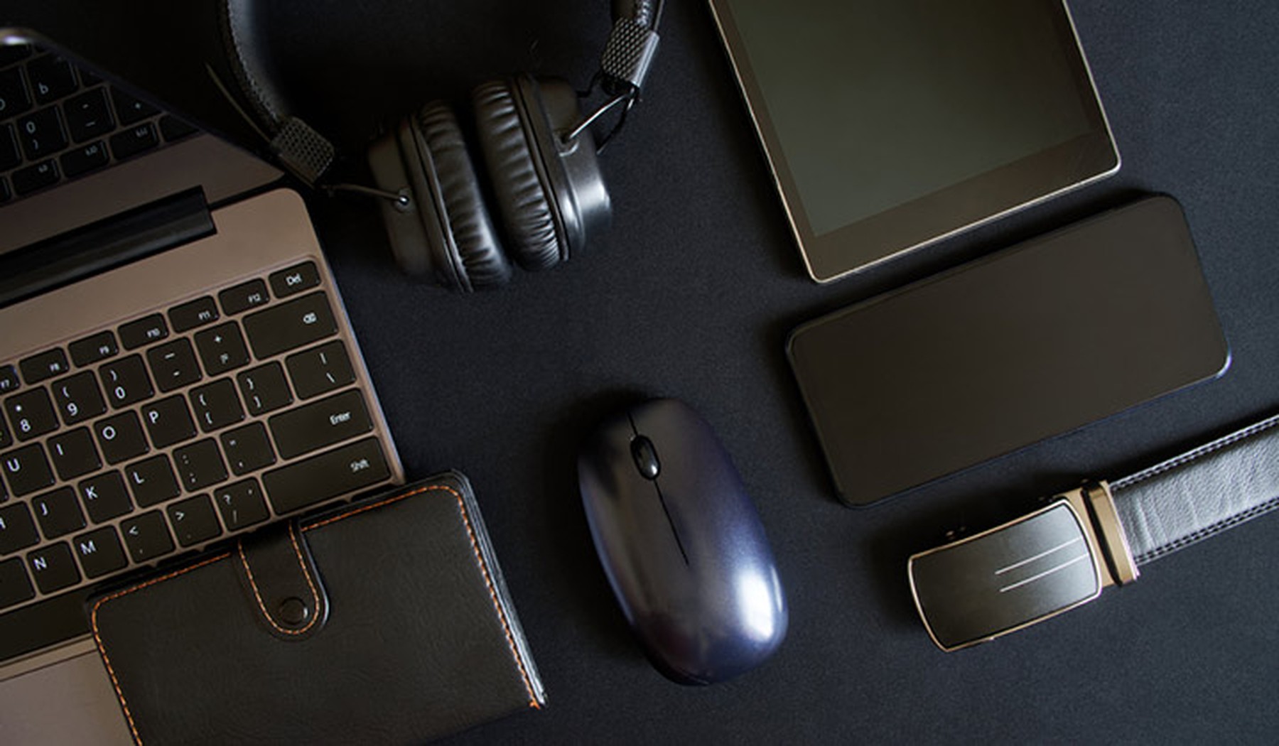portátil, cartera negra de cuero, auriculares negros, ratón negro, smartphone, smartwatch y tablet