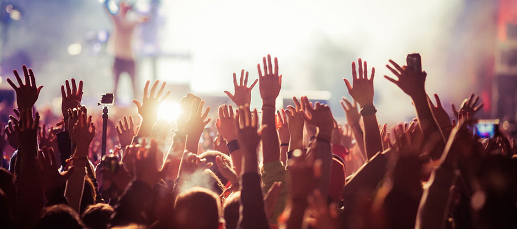 Personas con las manos alzadas en un festival de música