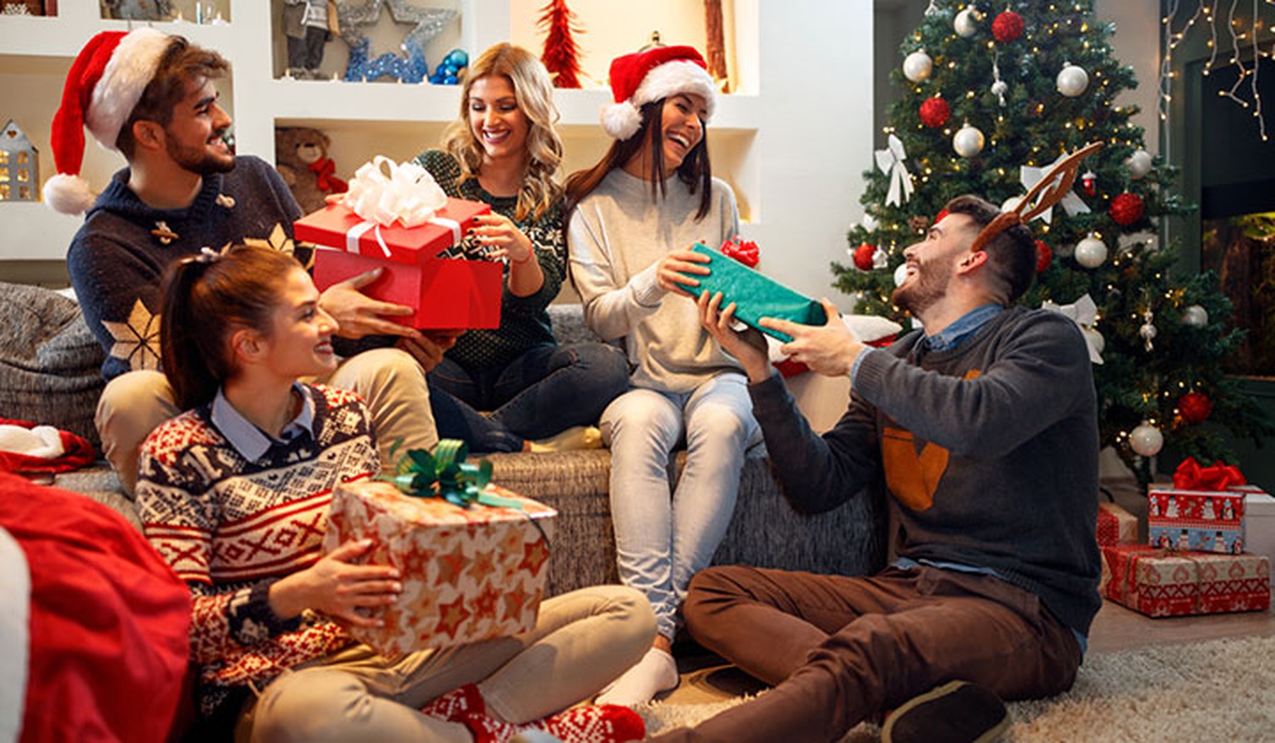 Jóvenes con regalos y decoración navideña