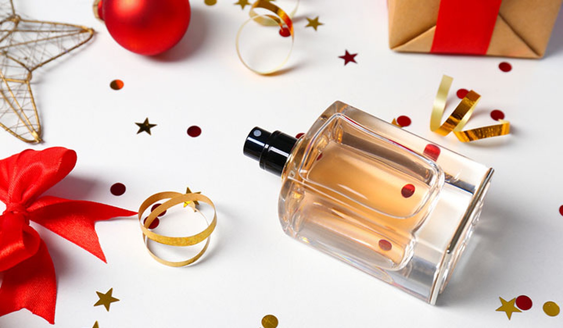 Perfume junto a decoración navideña y confeti