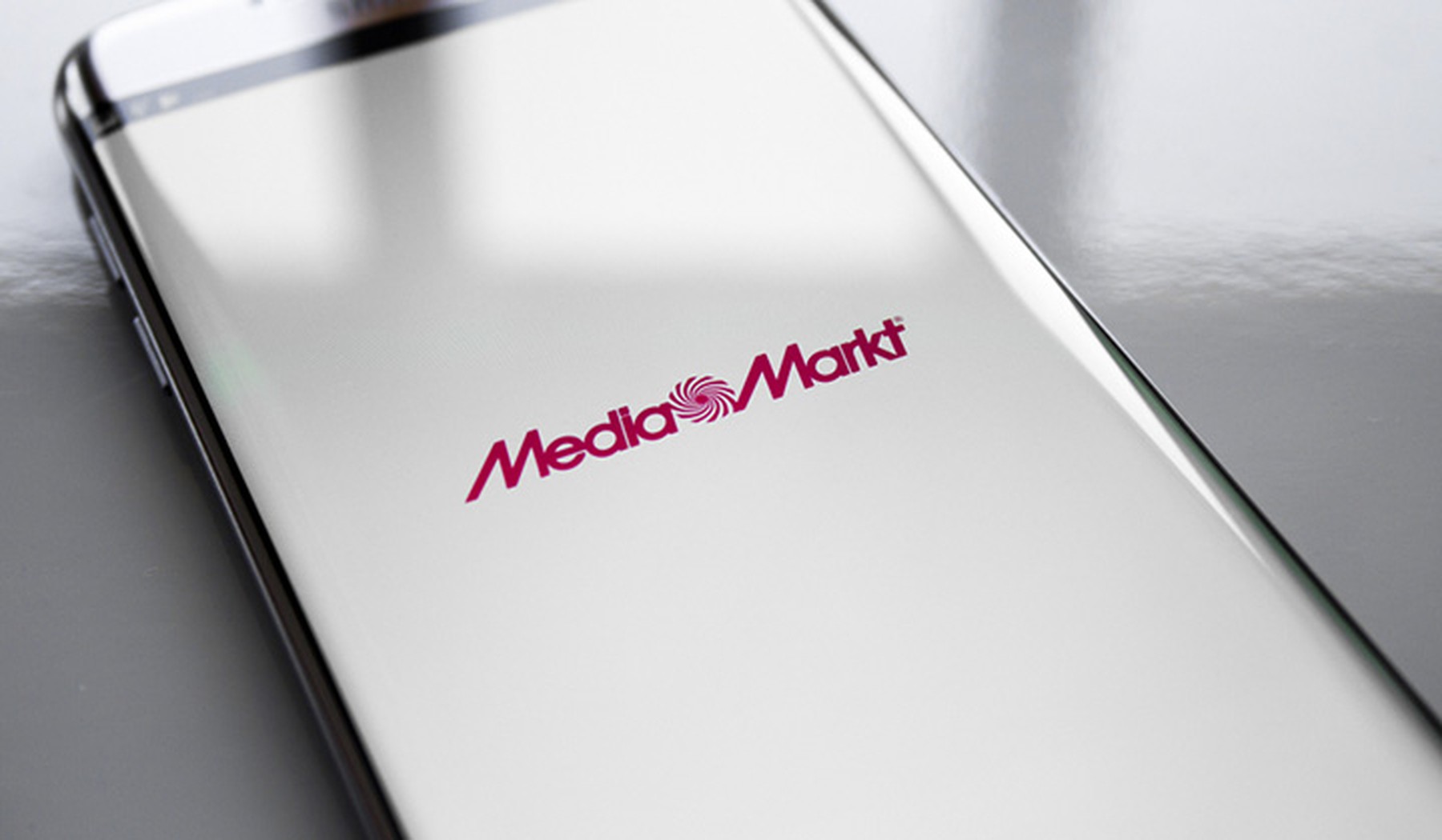 Smartphone con la pantalla en blanco y el logo de MediaMarkt en el centro con letras rojas