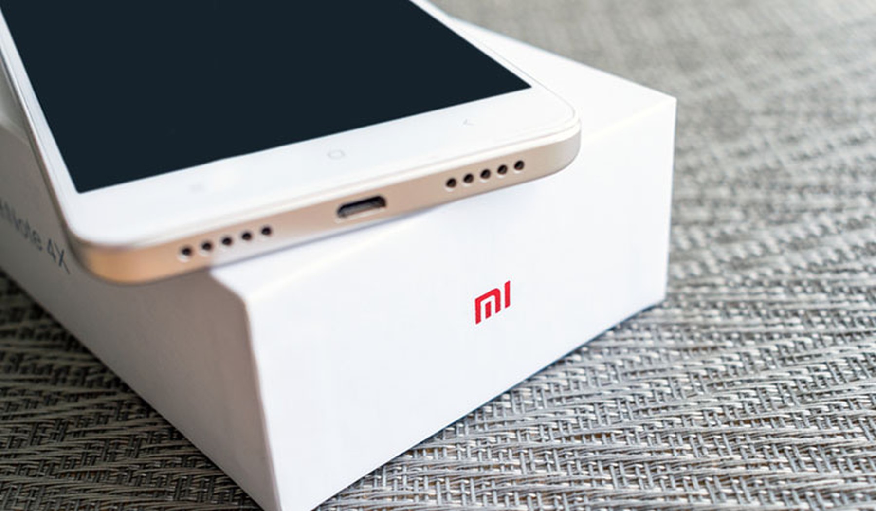 Teléfono nuevo sobre su caja con el logo de Xiaomi
