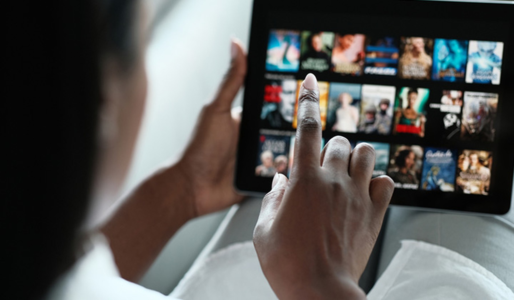 Mujer afroamericana seleccionando contenido audiovisual para ver en su tablet