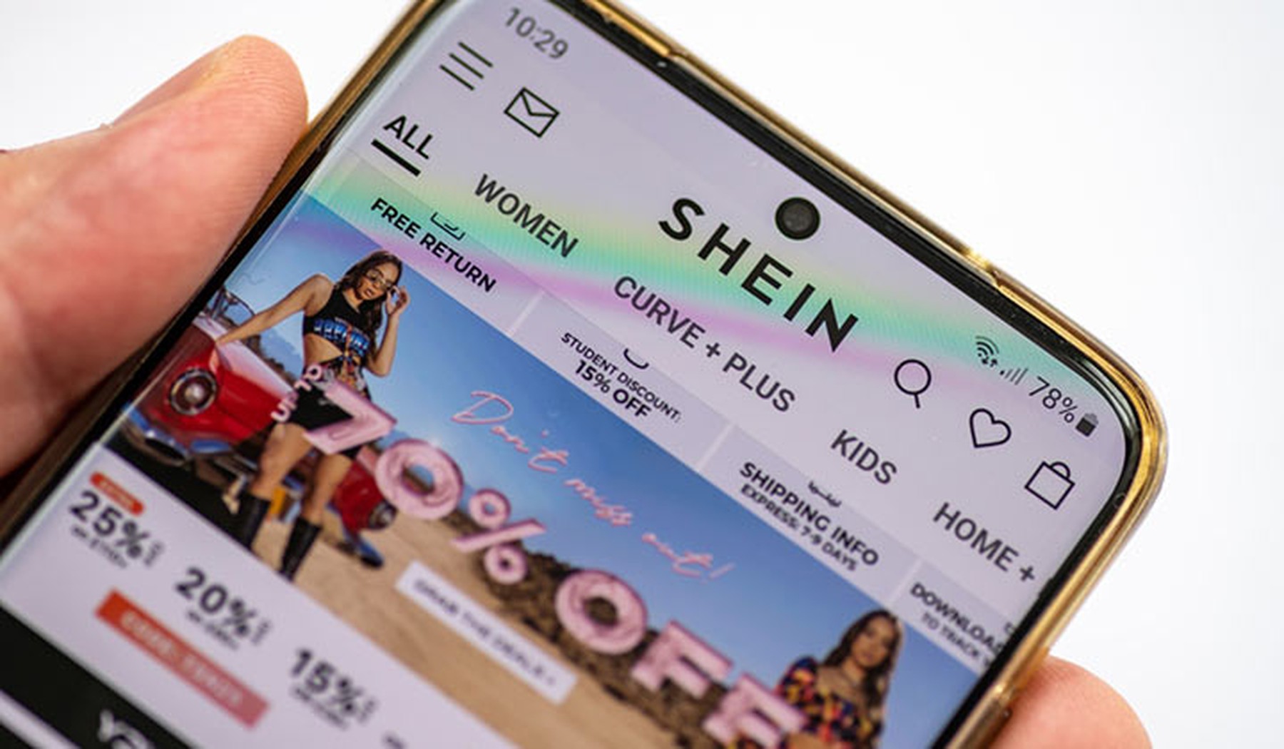 La página web del gigante minorista de moda rápida SHEIN en un smartphone cogido por la mano de una persona
