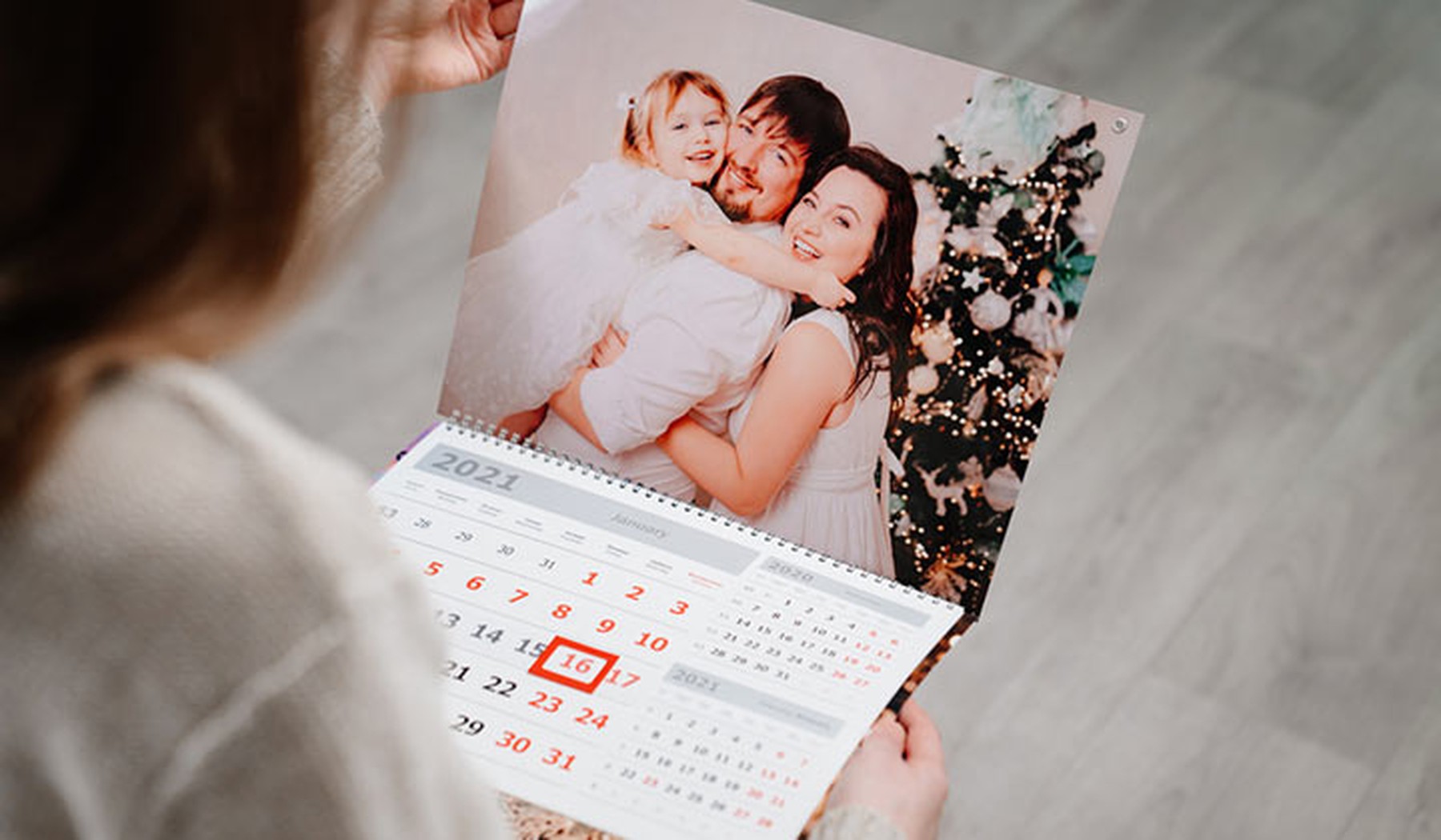 Una mujer mira un calendario personalizado con una foto familiar.