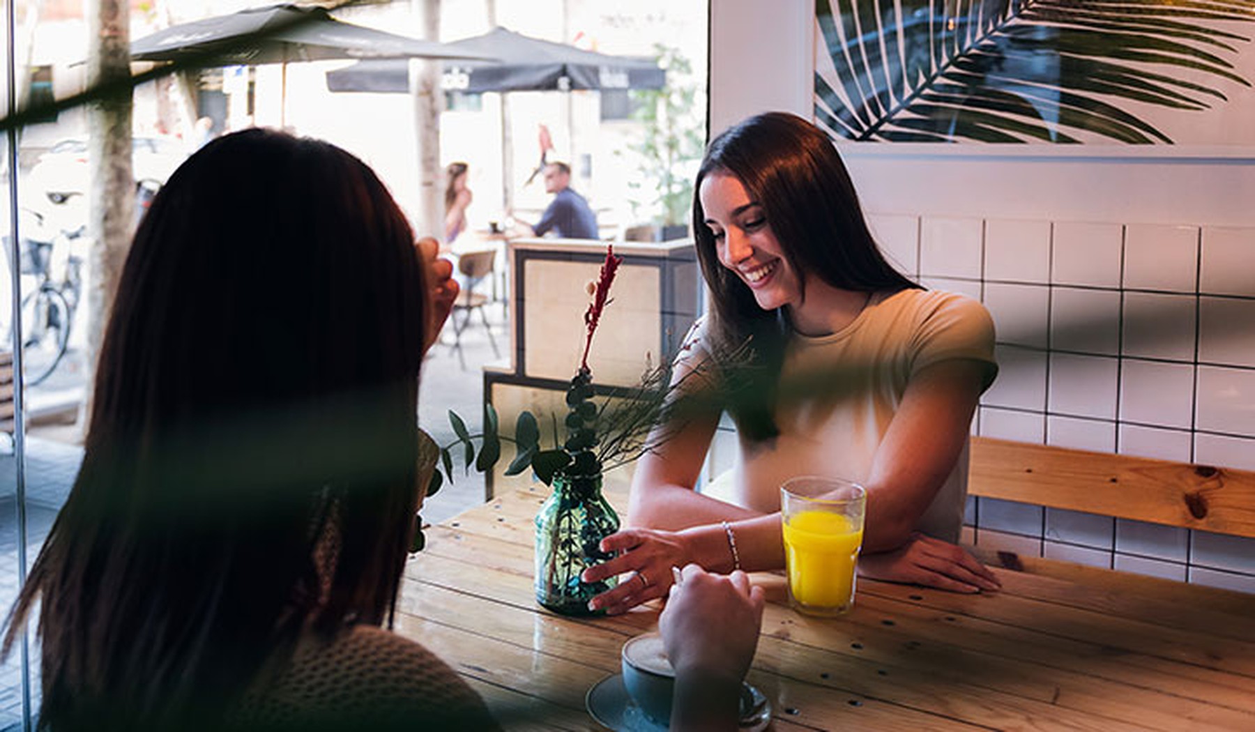 Dos mujeres jóvenes en una cita tomando algo en una cafetería
