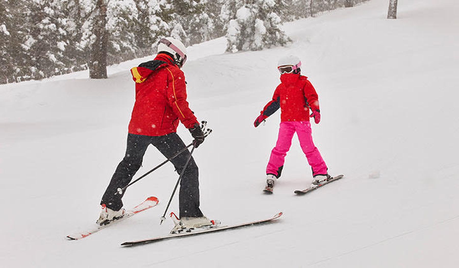 Padre e hija esquiando juntos