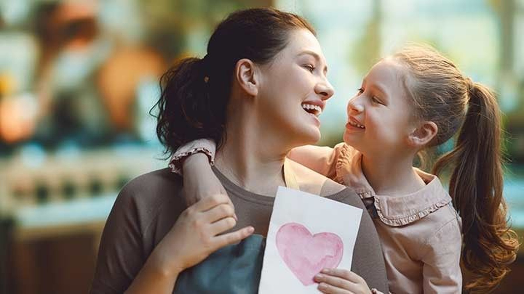 Madre e hija abrazadas con un dibujo de un corazón