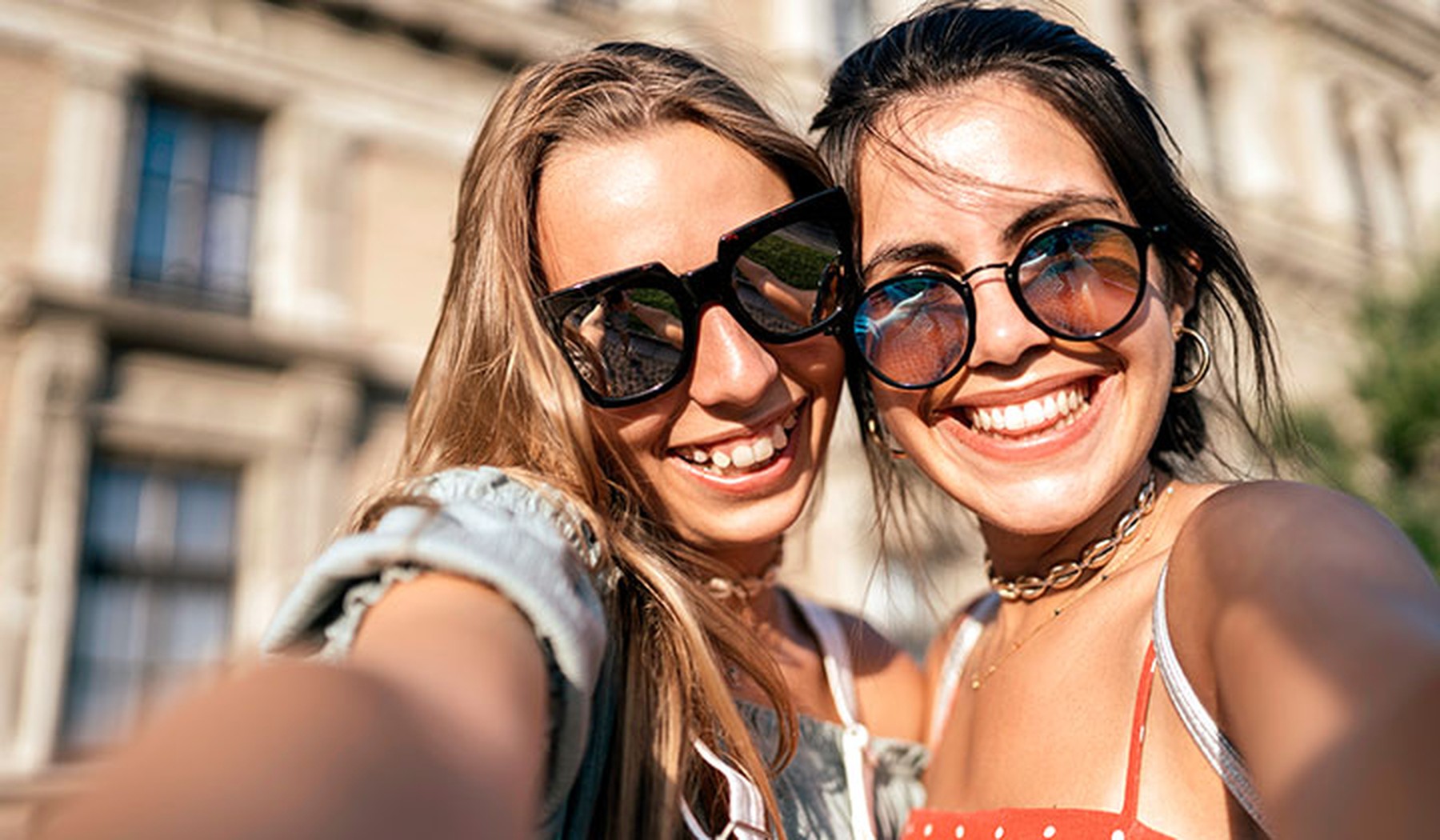 Mujeres jóvenes felices con gafas de sol tomándose un selfie