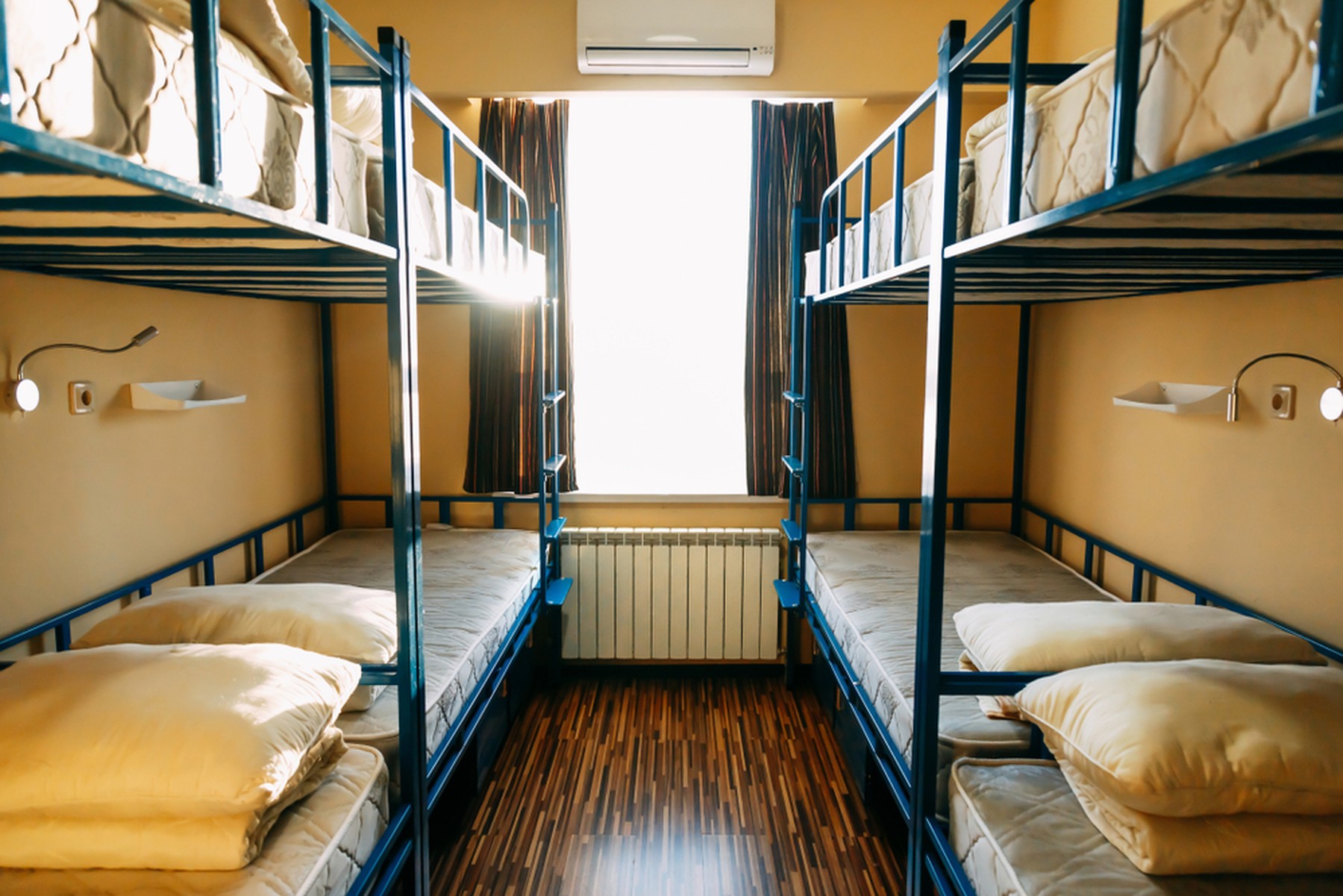 Habitación de un hostal de peregrinos con 4 literas con las camas sin hacer