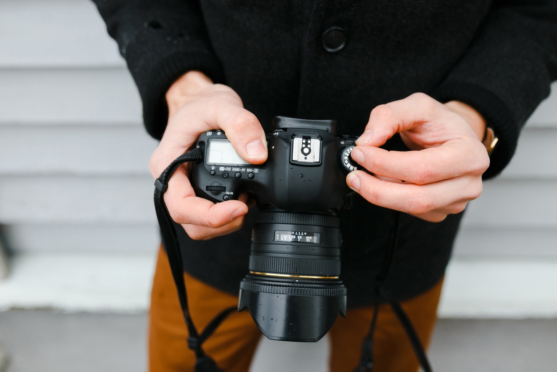 Las manos de un fotógrafo profesional ajusta una cámara antes de disparar