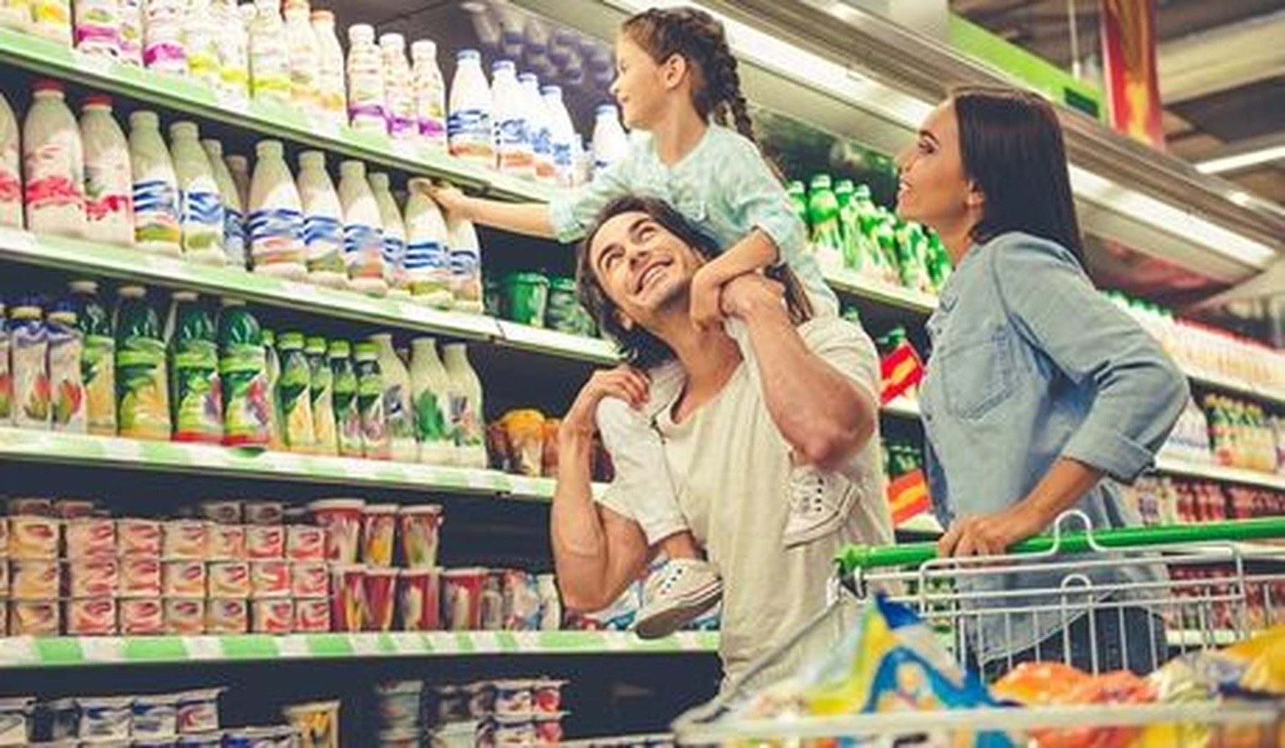 Padre, madre e hija en el supermercado haciendo la compra